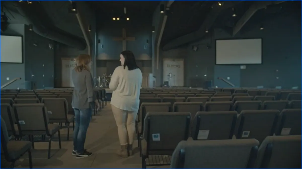 A partner talking with a volunteer at a community gathering.