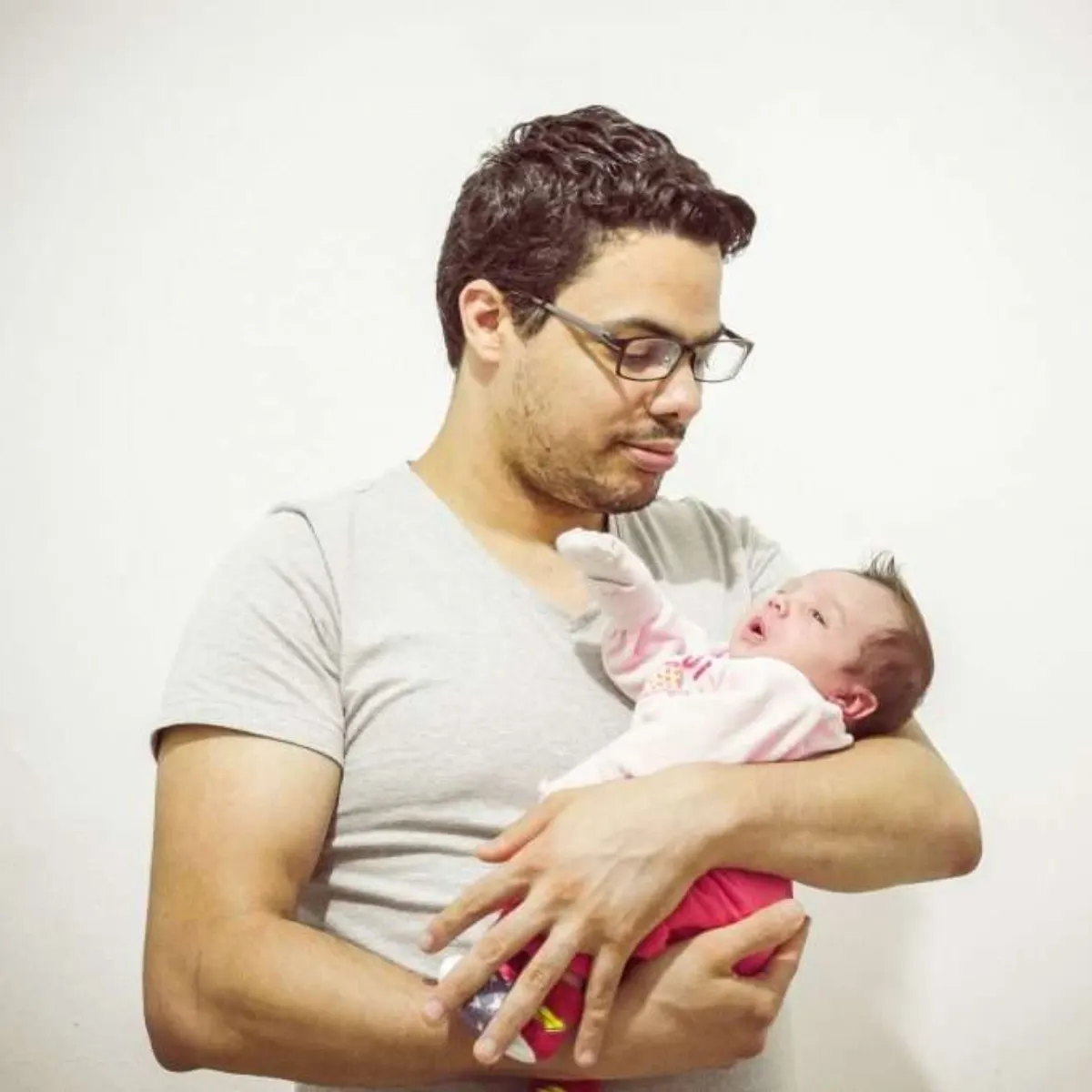 A parent gently holding a newborn.
